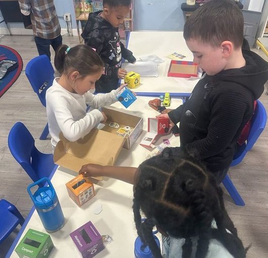 Children exploring letters and blocks at a classroom table