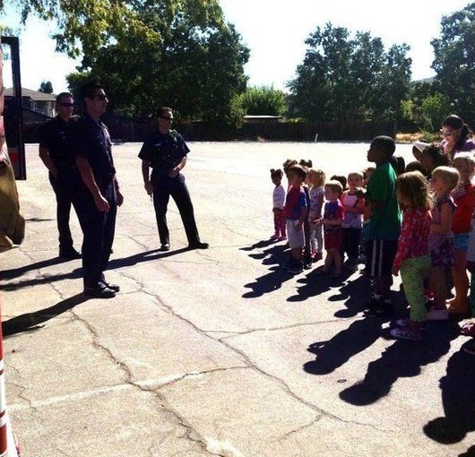 Children of all ages gathered outside during a fire station visit