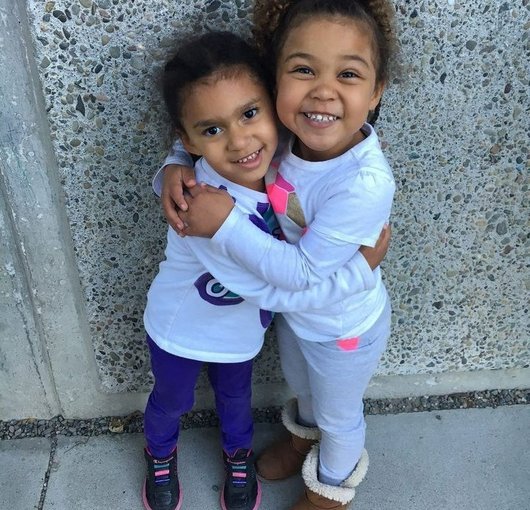 Two sisters hugging and smiling